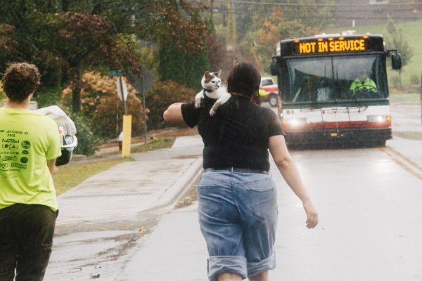 A resident carries their cat away from Bavarian Village apartment complex on Sept. 27. 