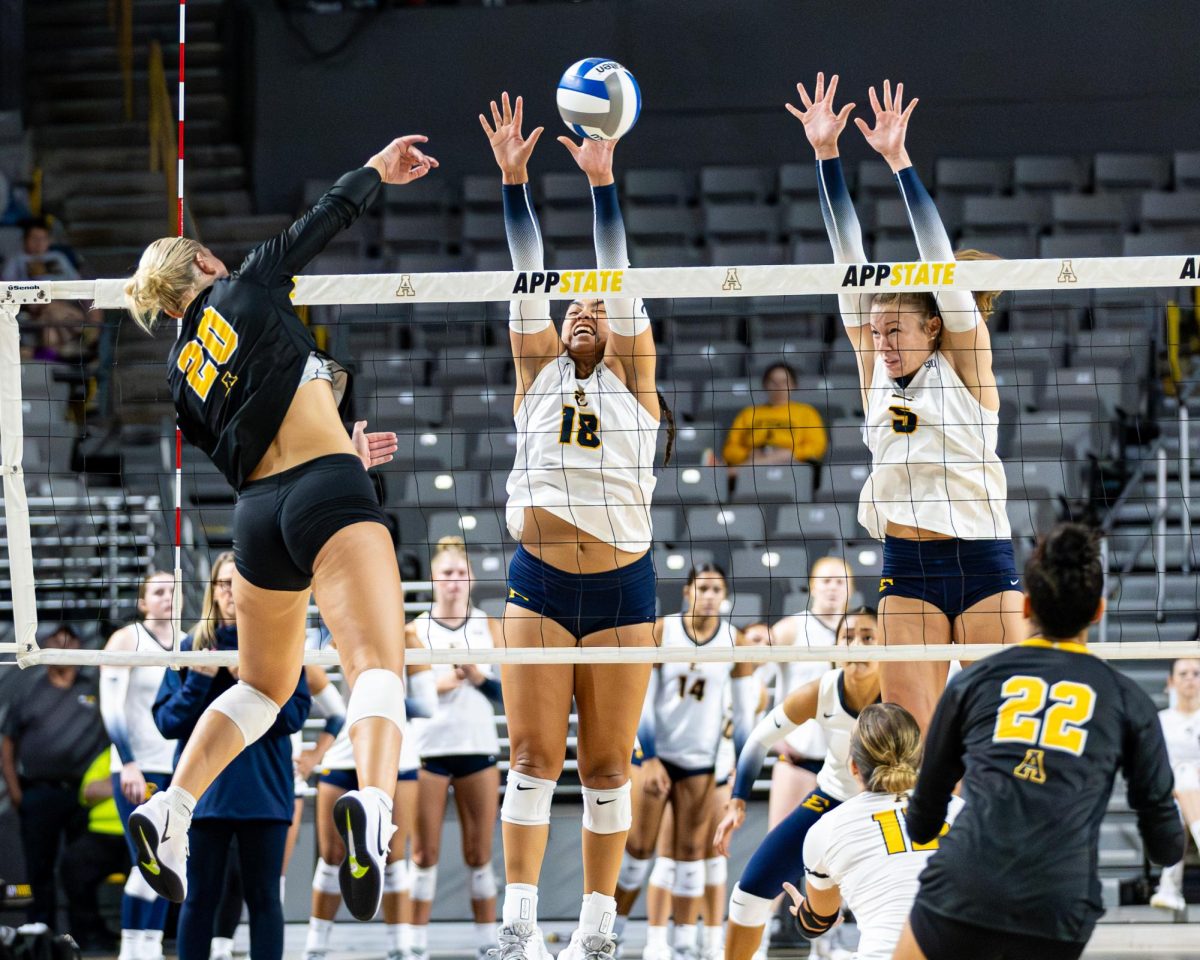 Outside hitter Maddie Smith spikes the ball between two ETSU defenders at the Holmes Convocation Center on Sept. 6. Smith had 15 kills and 8 digs against ETSU.