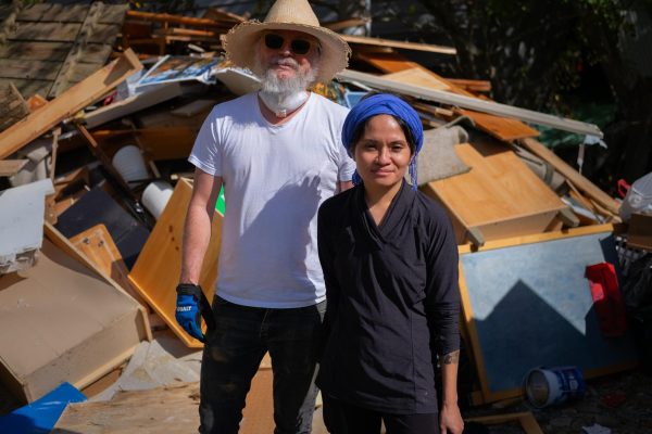  App State anthropology professors and Mountain Pathways parents Jon Carter and Christina Sornito stand in front of a pile of debris from the school on Oct. 5. The couple volunteered their time to rebuild their 4-year-old’s school.