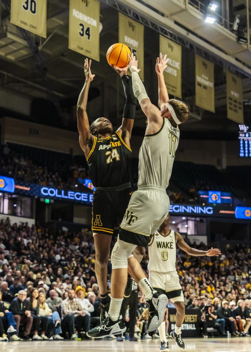 Forward Tre’Von Spillers jumps to dunk the ball at the App State vs. Wake Forest game on March 20. 