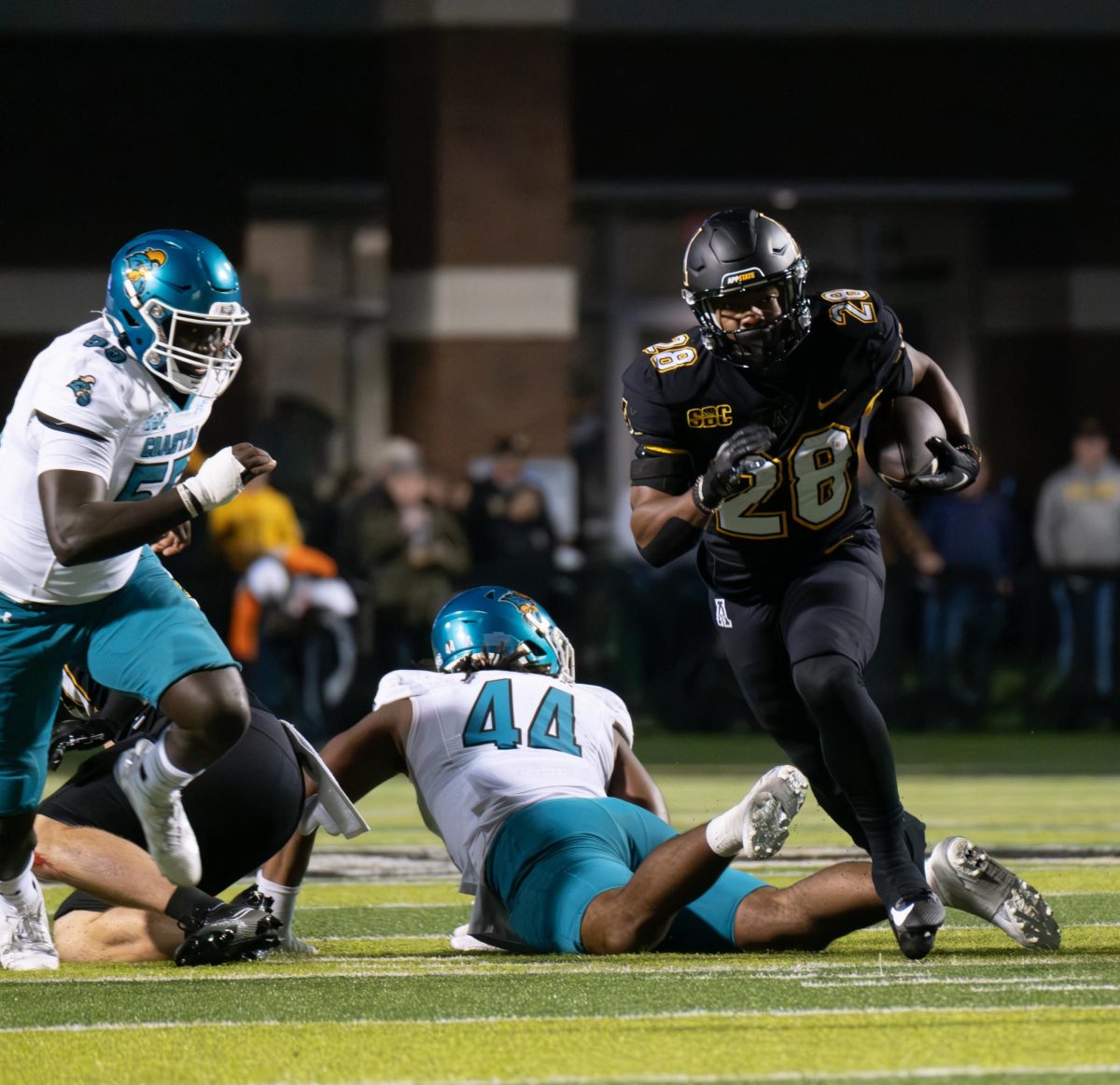 Running back Maquel Haywood evades Coastal Carolina players during the App State vs. Coastal Carolina game on Oct. 10, 2023.