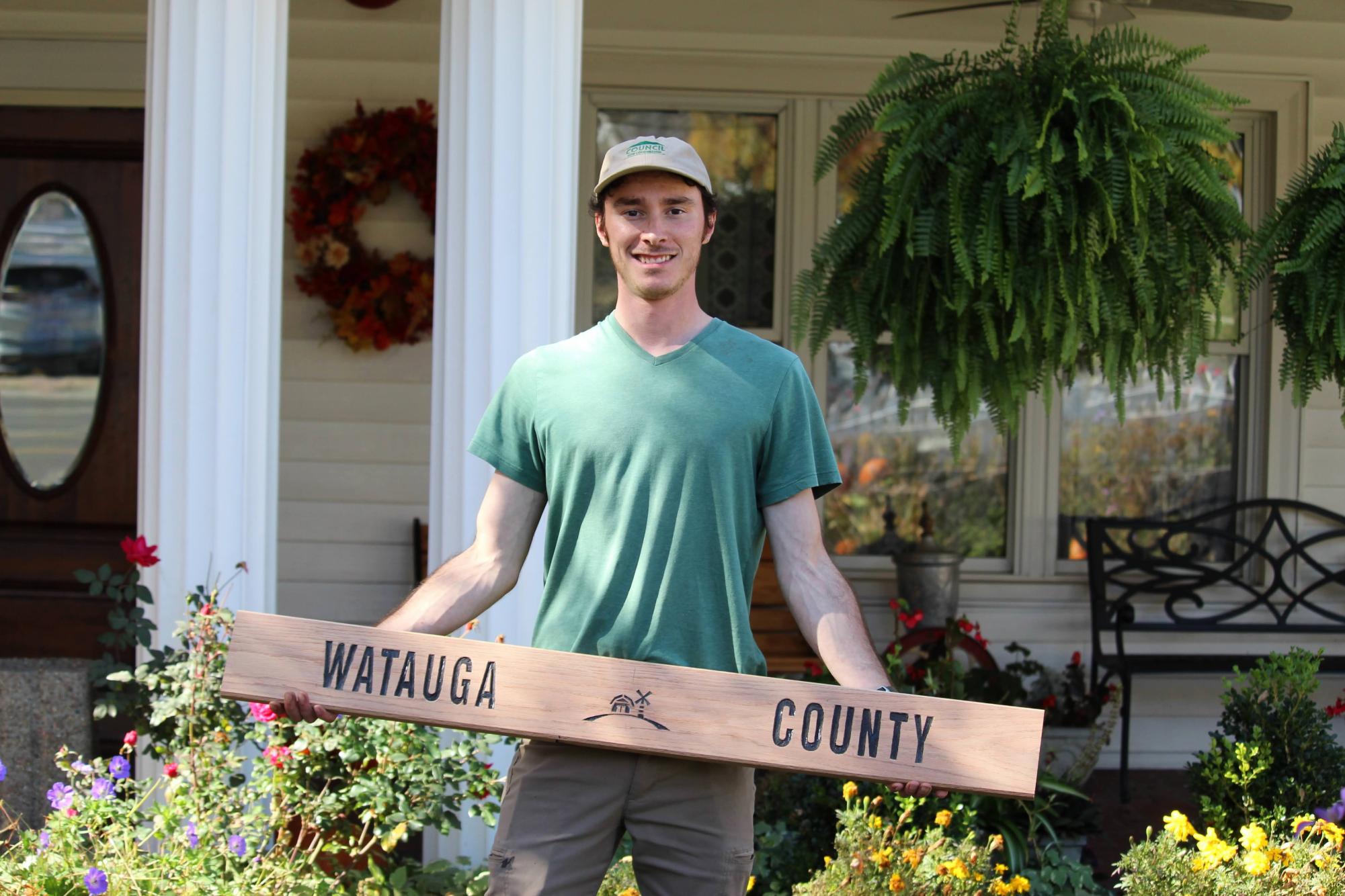 Nate Coppenbarger displays his current woodworking project in front of the Daniel Boone Inn on Oct. 31.