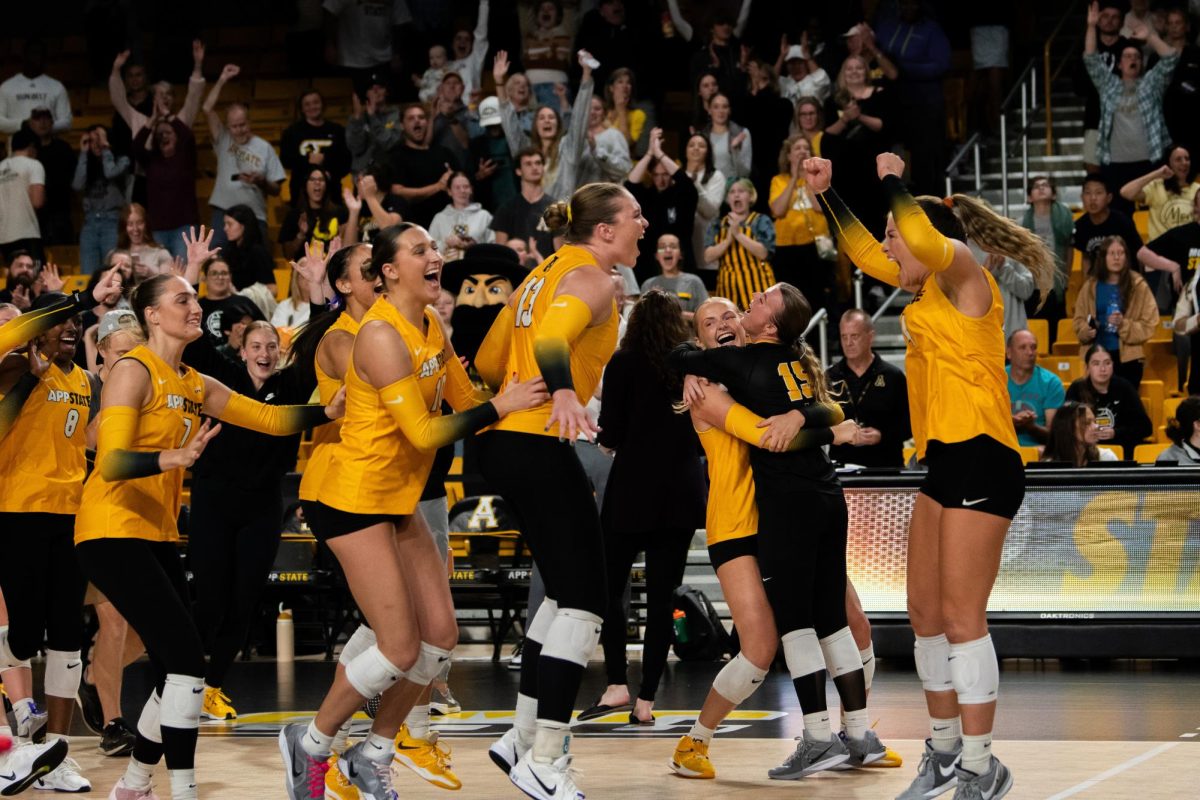 App State volleyball players celebrate after a win against Coastal Carolina on Oct. 25.