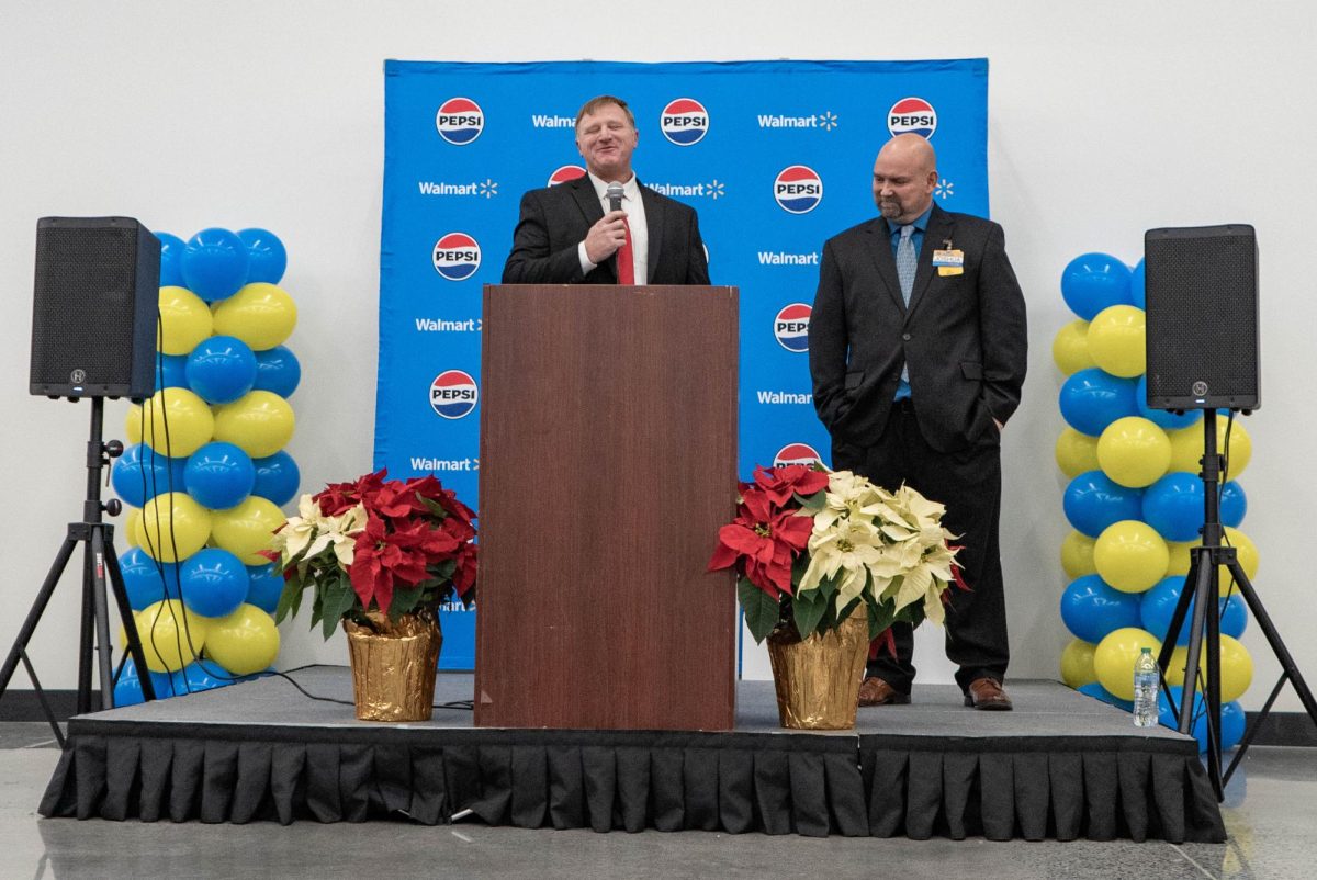 Michael Ricker of Bellview Baptist Missionary Church in Cranberry, N.C. leads the Boone Walmart Supercenter reopening event in prayer on Dec. 20. Walmart Store Manager Joshua Daniels stands next to him. 