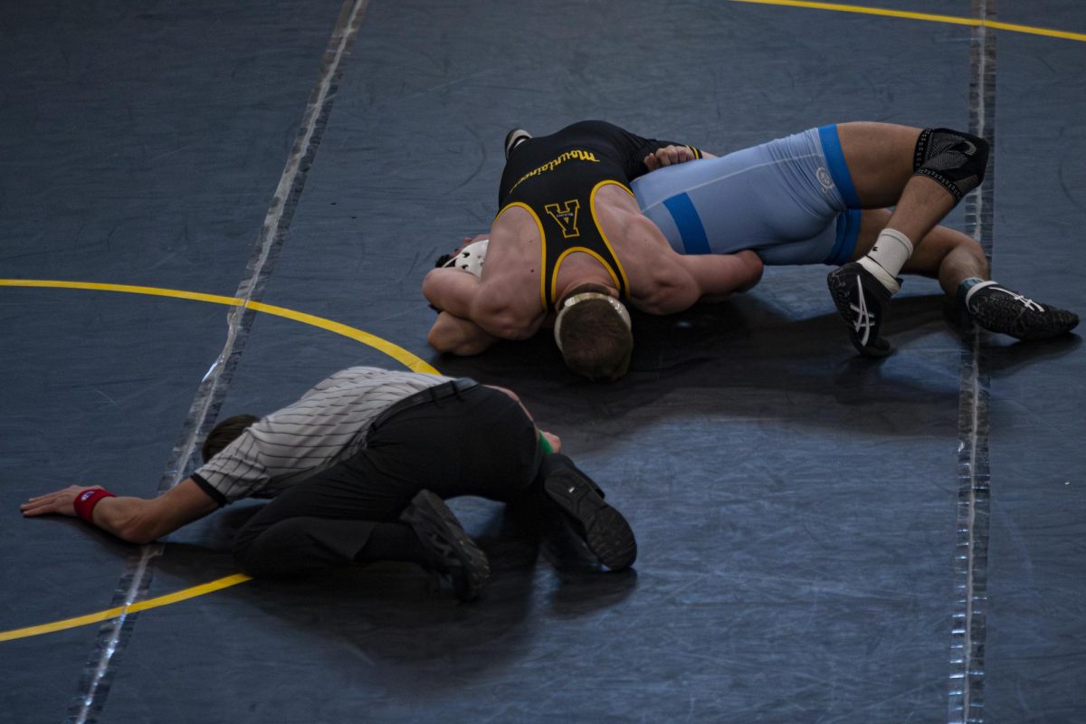 An App State wrestler pins his opponent while the referee watches for a pin on Jan. 25. 