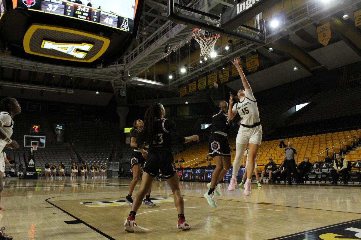 Senior App State guard Emily Carver goes for a layup over Arkansas State guard Crislyn Rose at Holmes Convocation Center on Dec. 29.