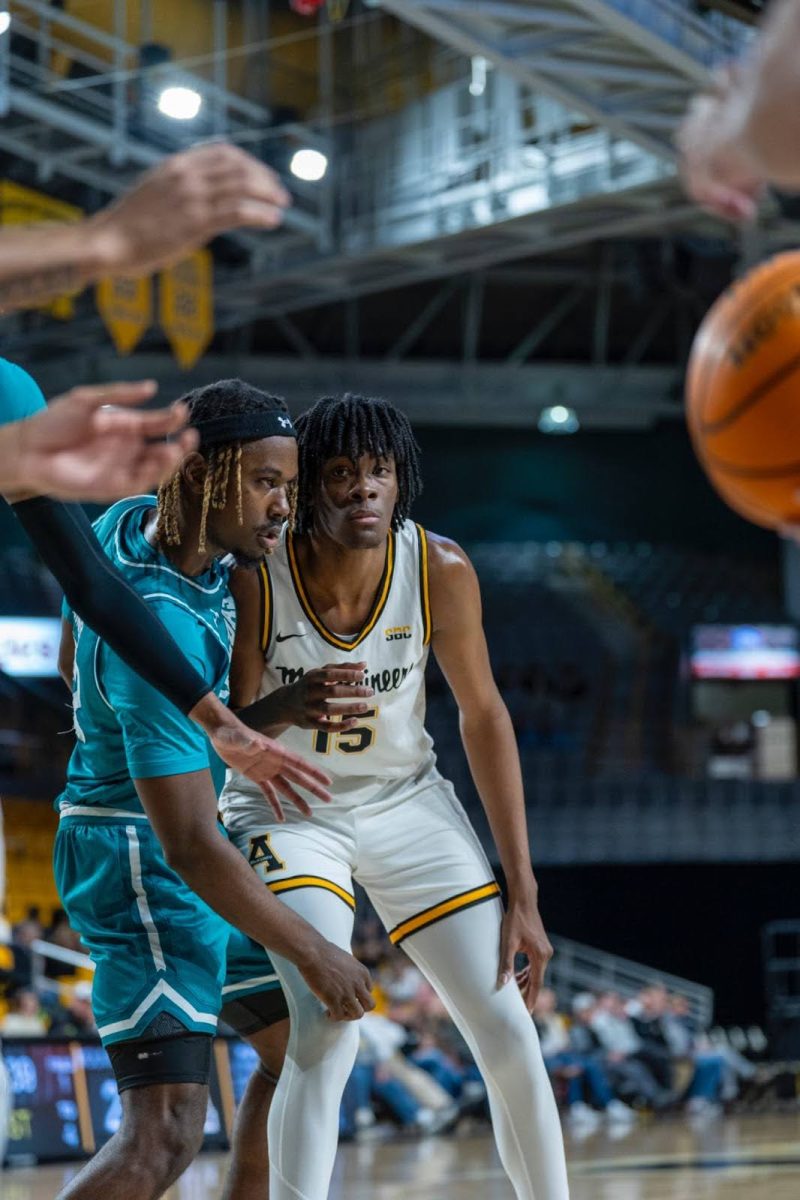 Graduate student forward CJ Huntley blocks a Coastal Carolina player on Jan. 8.