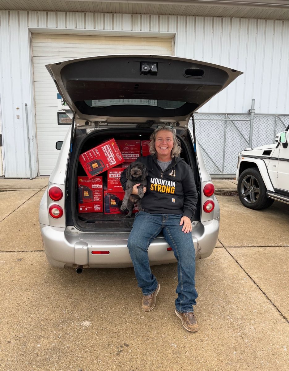 Charlene Powers Walsh and her dog Wanda sit in the trunk of her car, which she donated during her third trip to Western North Carolina. The car is packed with heaters. Courtesy of Charlene Powers Walsh.