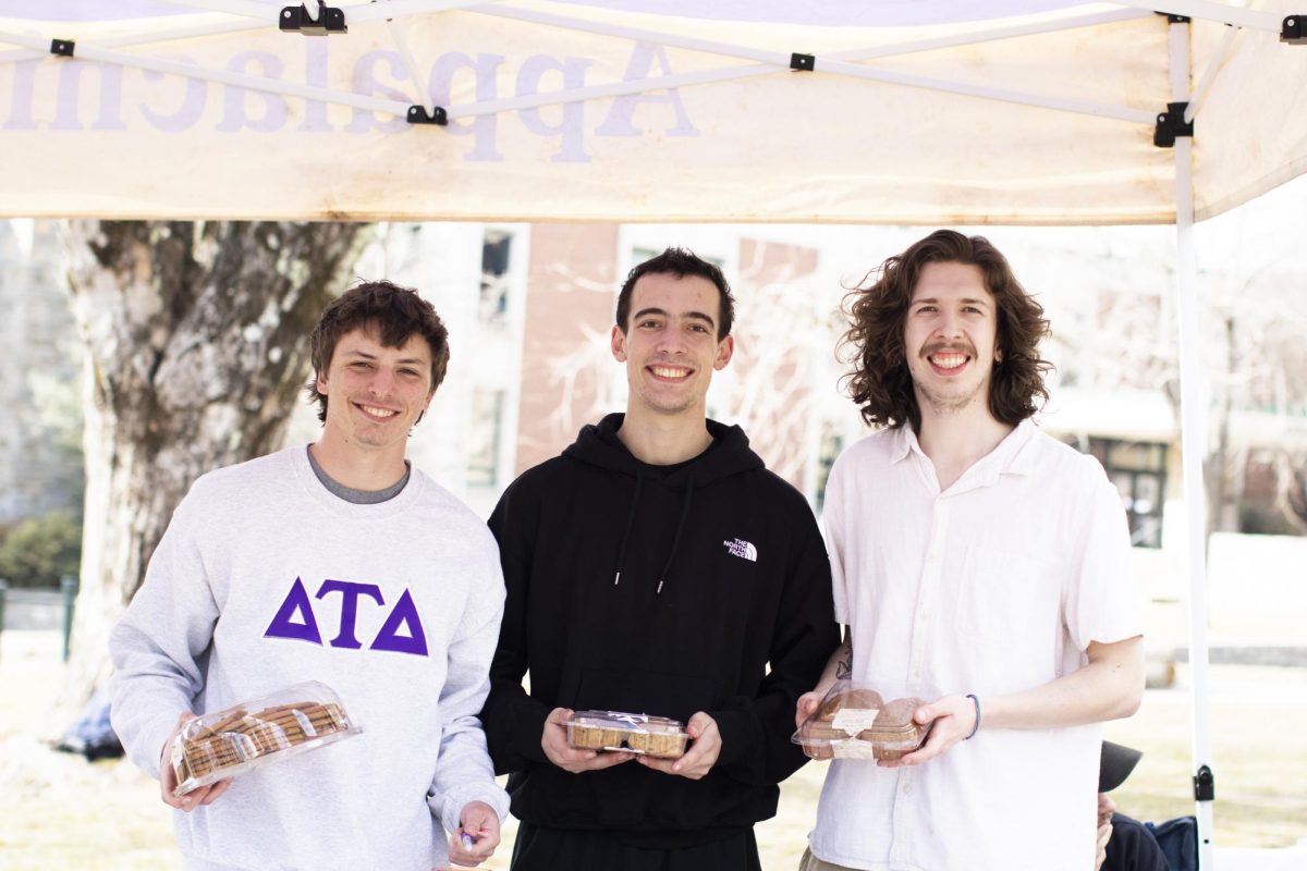 From left, Brannen Coe, Will Rothfuss and Ethan Ivey of Delta Tau Delta sell hot cocoa and cookies on Sanford Mall to App State students and professors on Feb. 6.