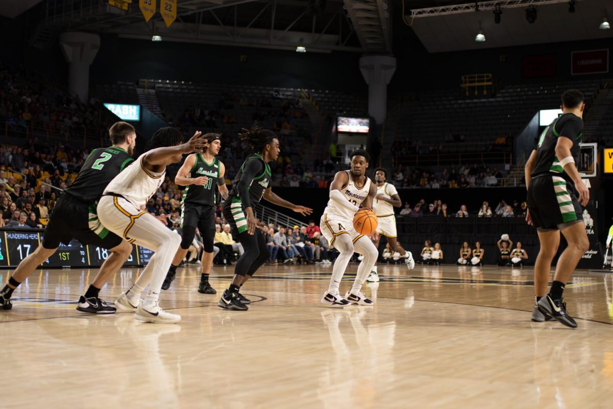 Senior guard Myles Tate passes to forward CJ Huntley in the post on Feb. 22. Tate had 4 assists against the Thundering Herd.