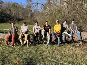 From left, members of the App State Off Roading Club Nick Skates, Trey Carlton, Brandon Beane, Alex Klassy, Aaron Brannock, JW Hiser and Thomas Sinn sit on a fallen tree. Courtesy of Brandon Beane.