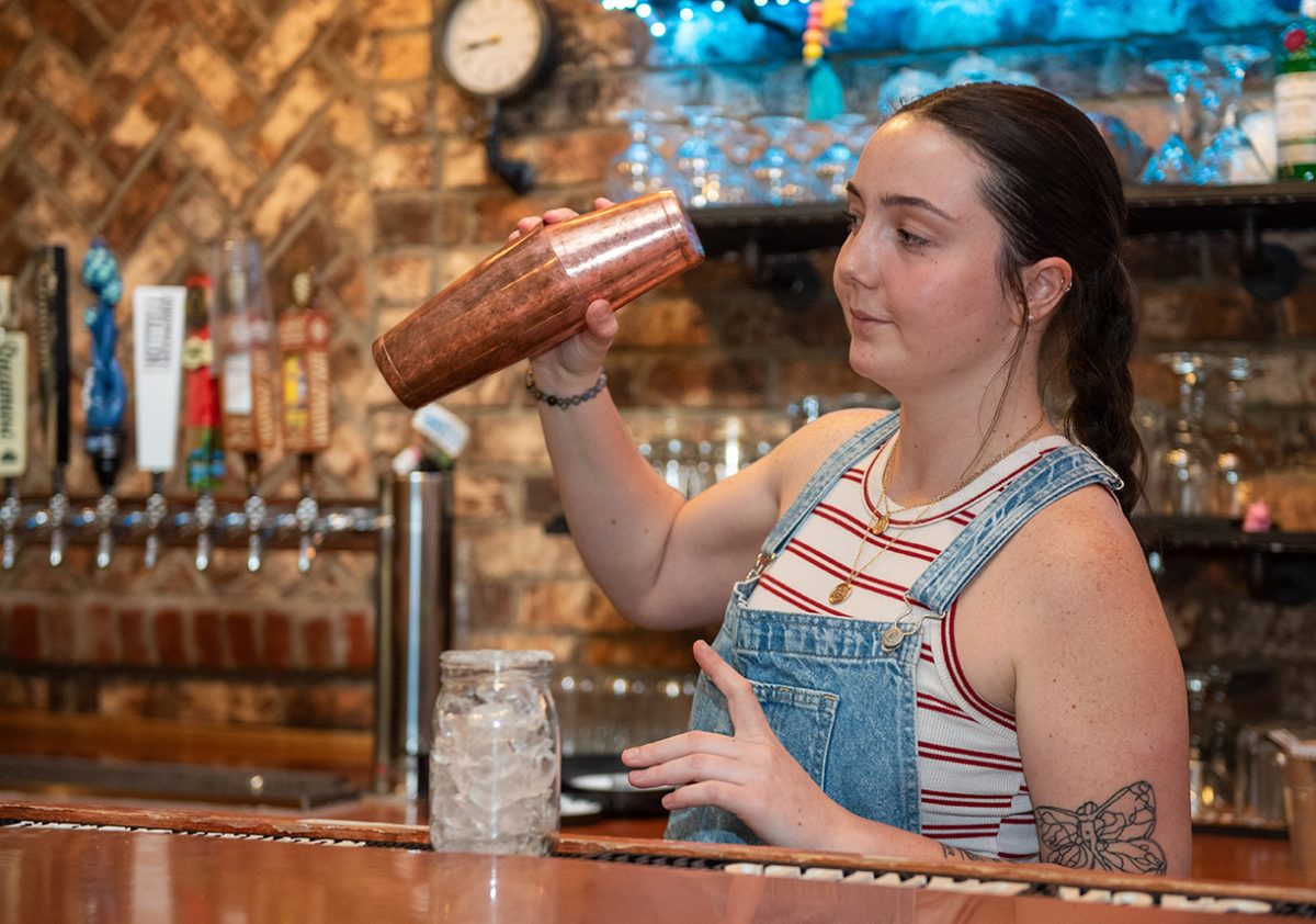 Manager Cariline Lampe shakes a signature margarita behind the bar of Howard Station on March 18.