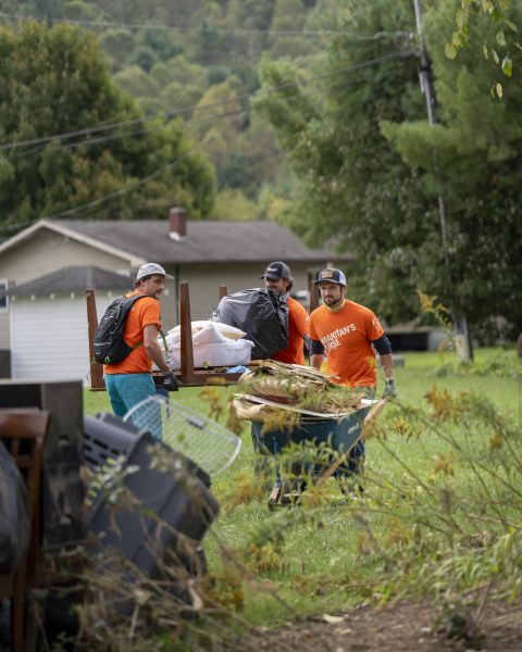 Volunteers of Samaritan's Purse move damaged items from the homes of Bavarian Village to the sidewalk for disposal pickup on Sept. 30 2024.