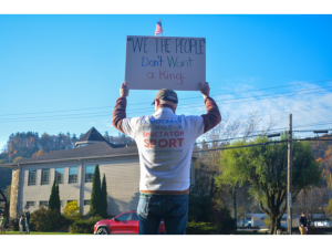Bill holds a sign reading “‘We the People’ don’t want a king” during the No Kings protest on Oct. 18.