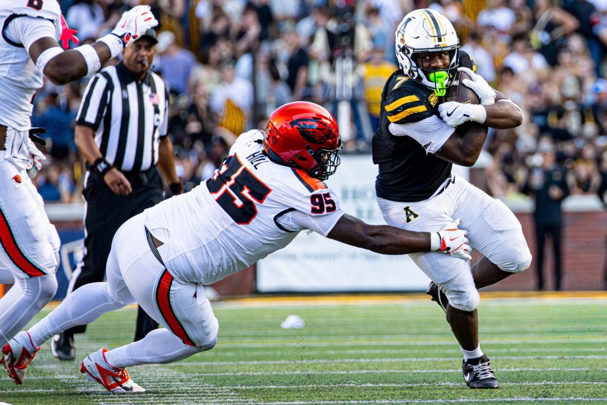 Senior running back Rashod Dubinion carries the ball towards the end zone, dodging an Oregon State defender at Kidd Brewer Stadium on Oct. 4.