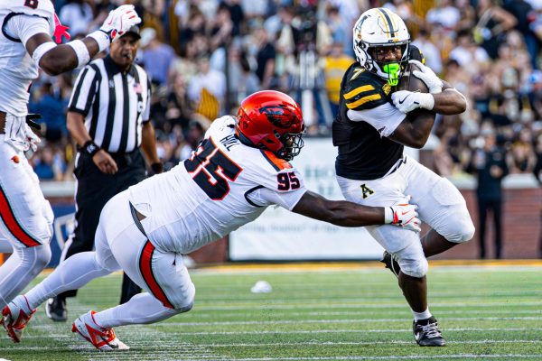 Senior running back Rashod Dubinion carries the ball towards the end zone, dodging an Oregon State defender at Kidd Brewer Stadium on Oct. 4.