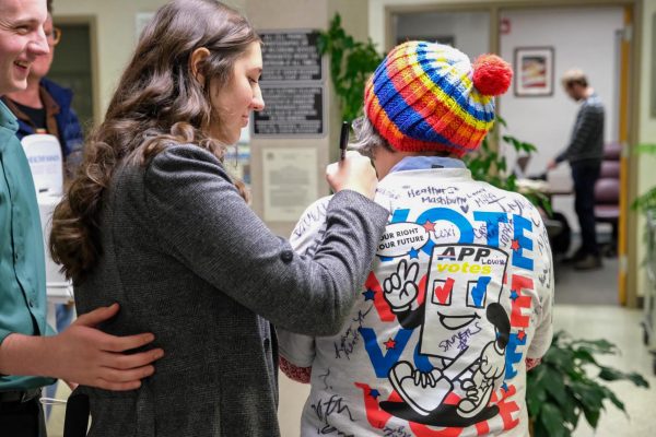 Un voluntario firma la camiseta de Virginia Roseman, candidata al Concejo Municipal de Boone, en el Watauga County Courthouse el 4 de noviembre.
