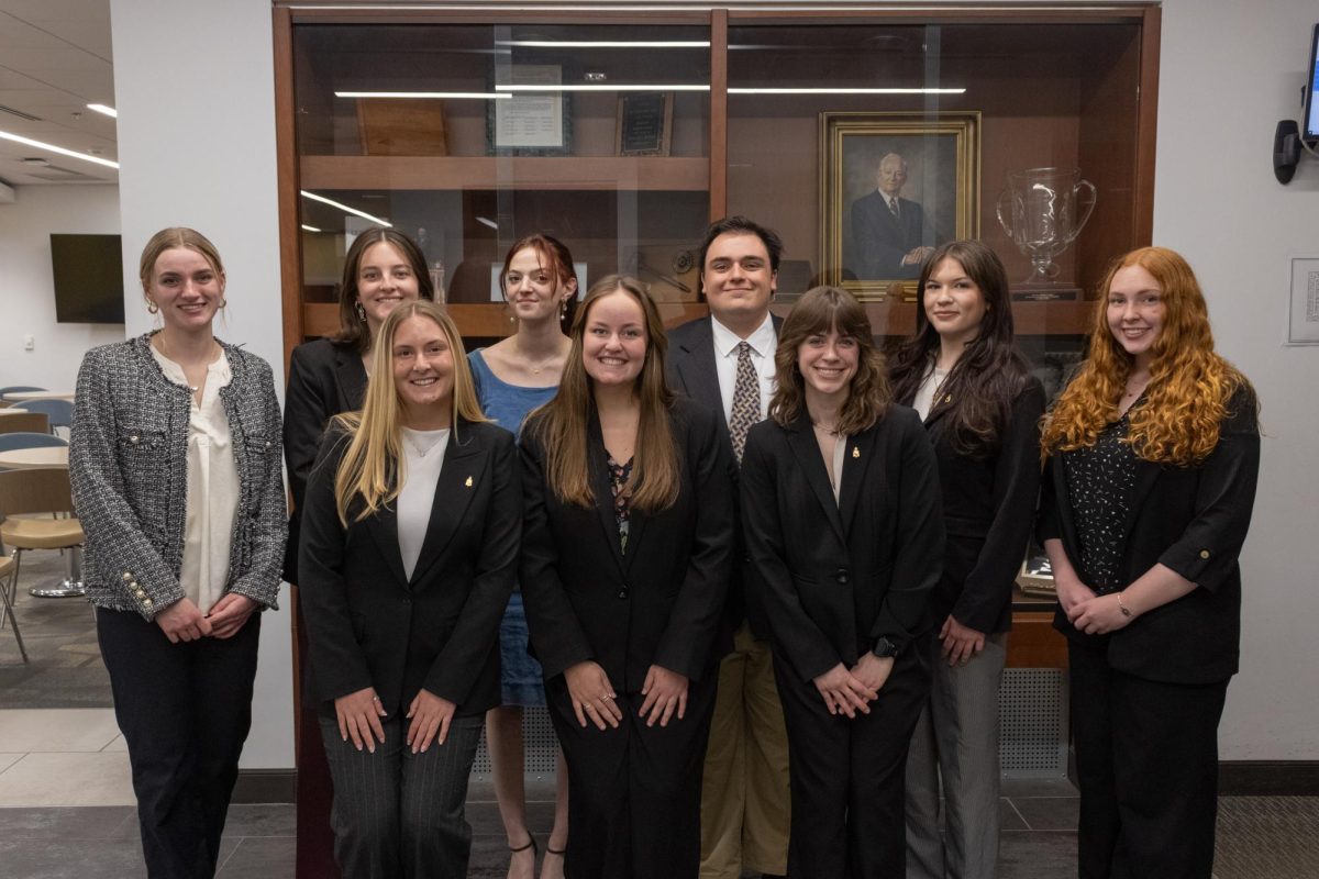 The executive board for Pi Sigma Epsilon Maggie Bassinger, Naomi Cannon, Abby Maske, Richard Knudson, Abby Rini, Maya Tongue, Emily Picca, Connelley Weaver and Cora Passarelli pose for a photo in the lobby of Peacock Hall on March 3.