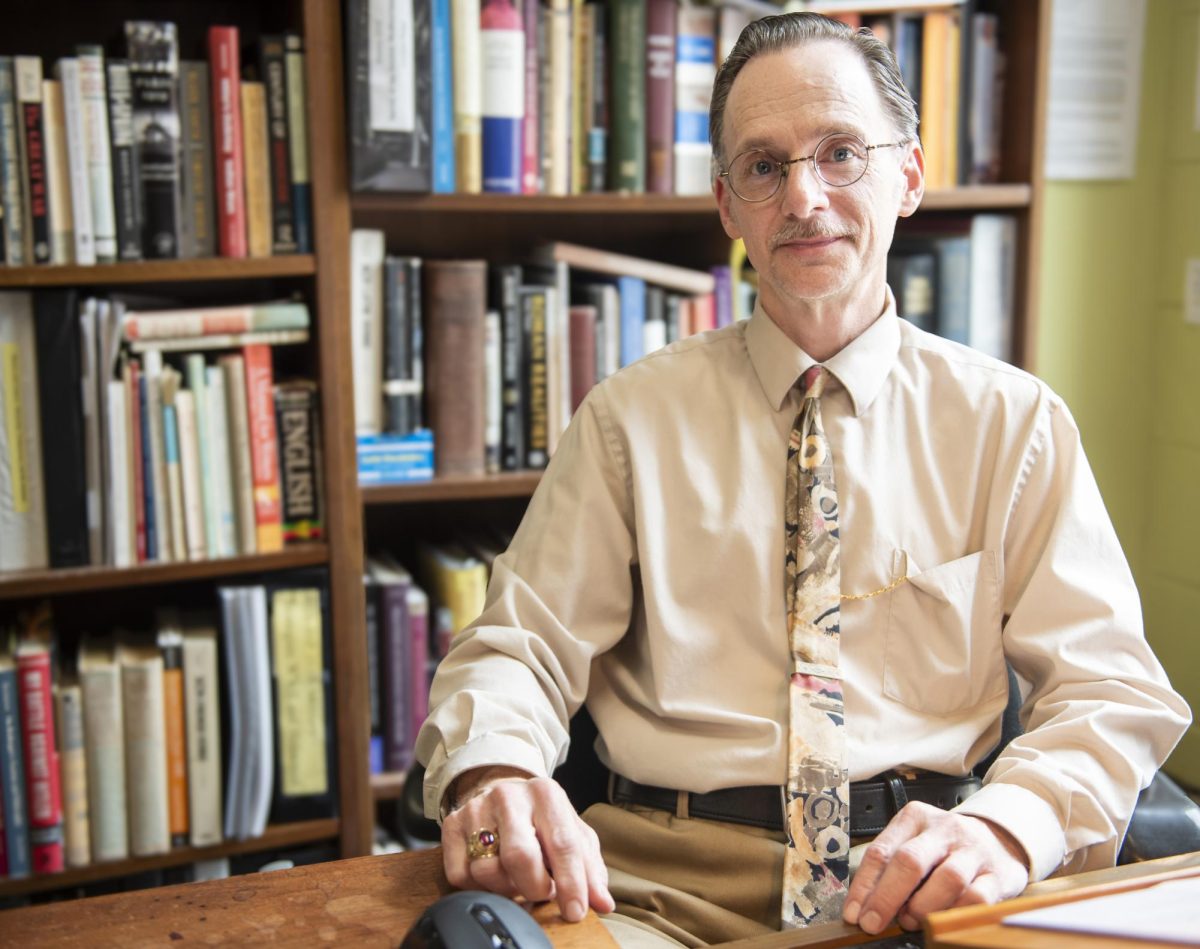Professor and App State alum Ralph Lentz sits in front of the bookshelf in his office in Anne Belk Hall on April 13.